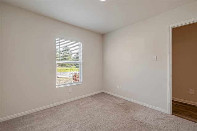 carpeted spare room featuring baseboards