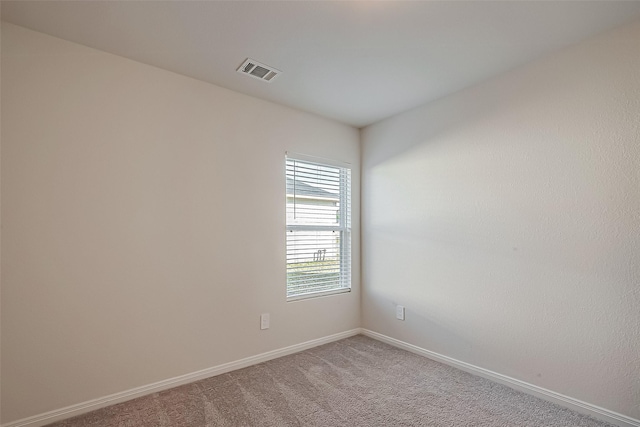 unfurnished room with light colored carpet, visible vents, and baseboards