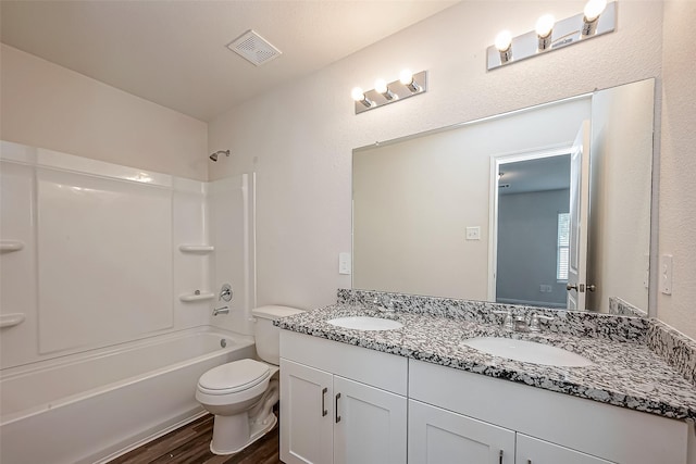 full bathroom with double vanity, visible vents, toilet, a sink, and wood finished floors