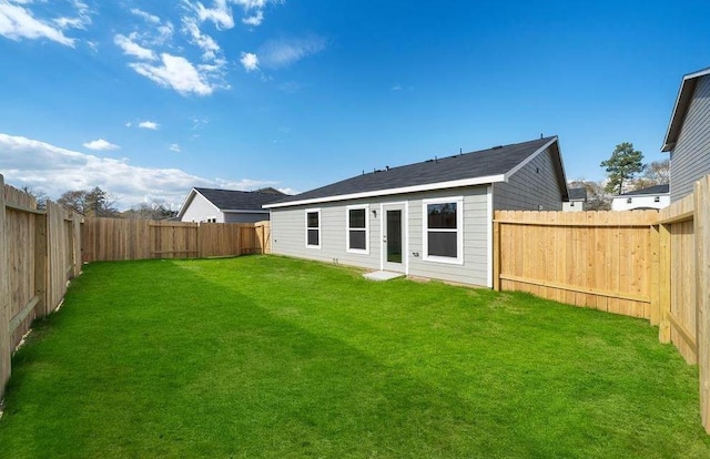 back of property featuring a lawn and a fenced backyard