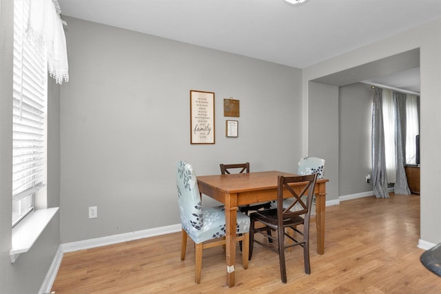 dining space featuring light wood-style floors and baseboards