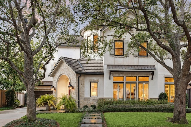 exterior space with driveway, stone siding, fence, and a yard