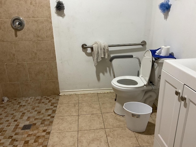 bathroom featuring toilet, tiled shower, and tile patterned floors