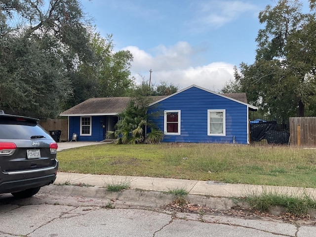 single story home with a front yard and fence