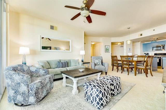 living area featuring light carpet, ceiling fan, and visible vents