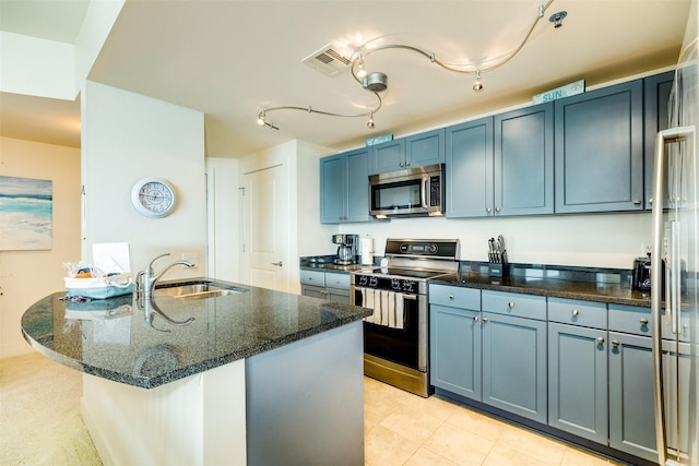 kitchen with stainless steel appliances, visible vents, a sink, blue cabinets, and dark stone counters