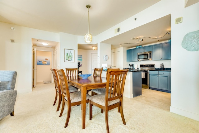 dining area featuring baseboards, visible vents, and light colored carpet