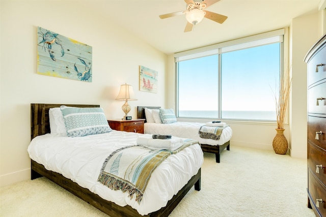 bedroom with a water view, a ceiling fan, baseboards, and carpet flooring