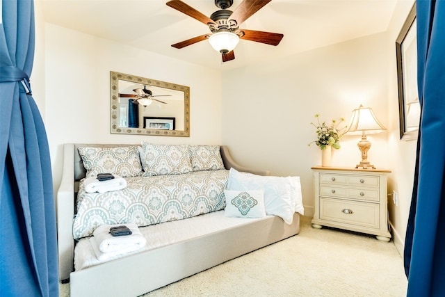 bedroom with a ceiling fan, light carpet, and baseboards