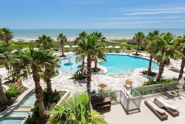 pool featuring a water view and a patio area