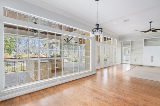 unfurnished dining area with built in features, a ceiling fan, wood finished floors, crown molding, and recessed lighting