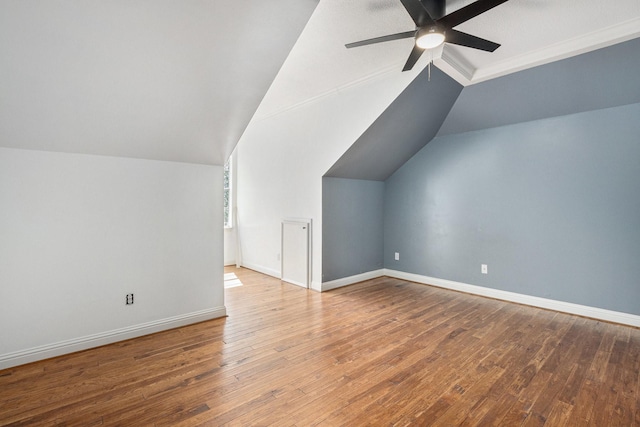 additional living space with lofted ceiling, a ceiling fan, hardwood / wood-style flooring, and baseboards