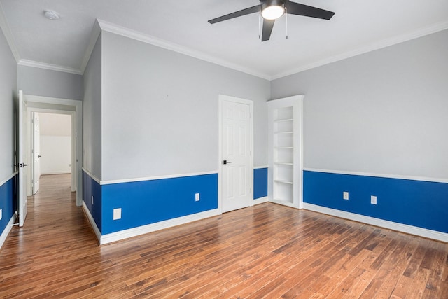 unfurnished room featuring crown molding, ceiling fan, wood finished floors, and baseboards