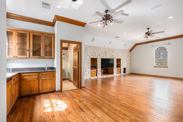 kitchen featuring ornamental molding, brown cabinetry, a sink, and visible vents