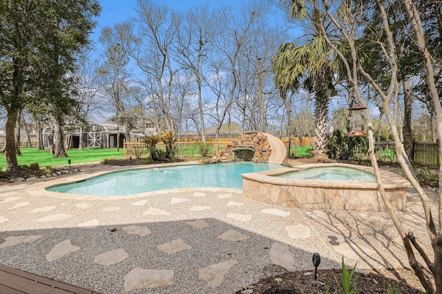 pool with a water slide, fence, a lawn, and an in ground hot tub