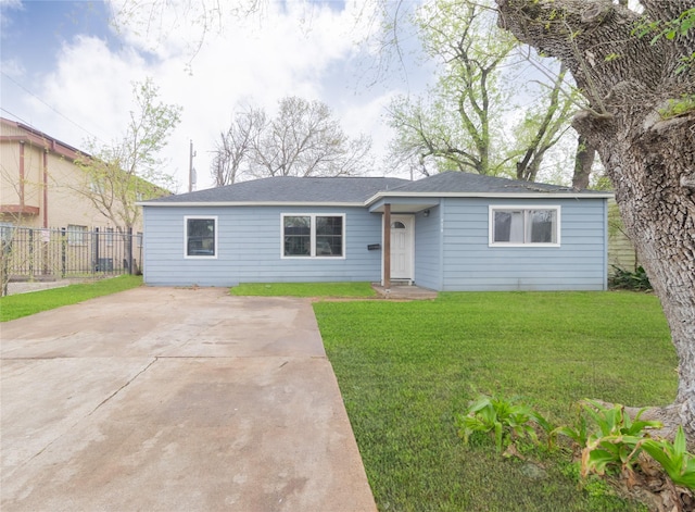 ranch-style home with driveway, a front yard, and fence