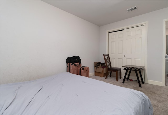 bedroom with a closet, carpet flooring, visible vents, and baseboards