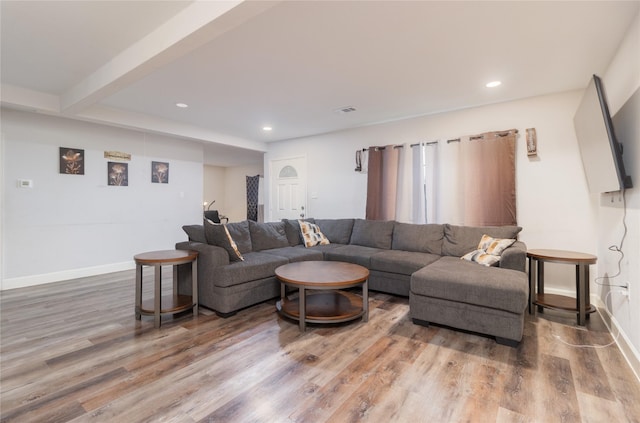 living room with visible vents, baseboards, wood finished floors, and recessed lighting