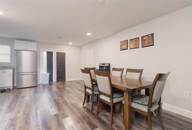 dining room with recessed lighting, wood finished floors, and baseboards