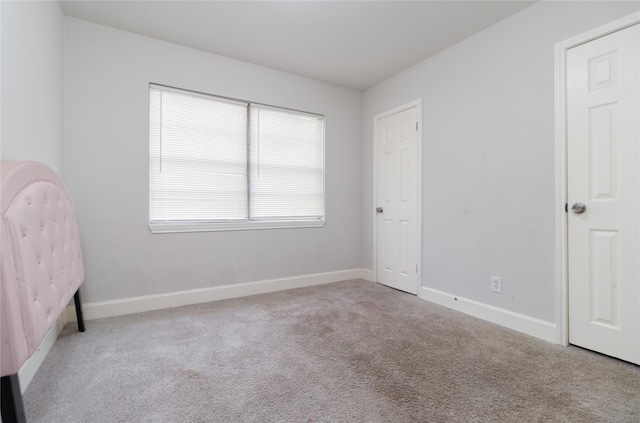 unfurnished bedroom featuring carpet and baseboards