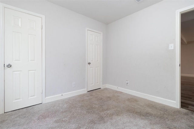 unfurnished bedroom with carpet floors and baseboards