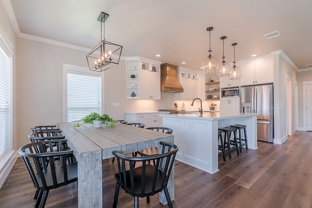 kitchen with a center island with sink, custom exhaust hood, open shelves, visible vents, and appliances with stainless steel finishes