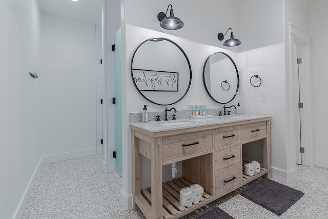 bathroom with double vanity, baseboards, and a sink