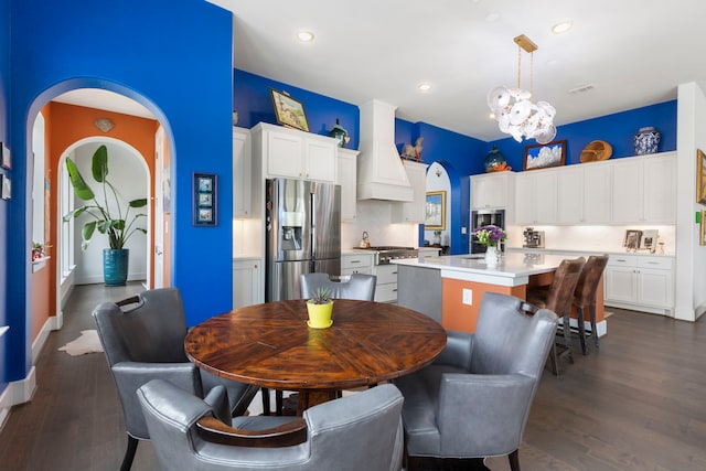 dining room with baseboards, arched walkways, dark wood finished floors, a chandelier, and recessed lighting