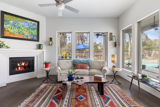 interior space featuring a ceiling fan and a glass covered fireplace