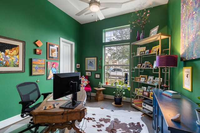 home office with wood finished floors, a ceiling fan, and baseboards