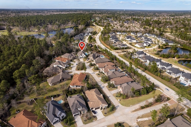 aerial view featuring a forest view, a water view, and a residential view