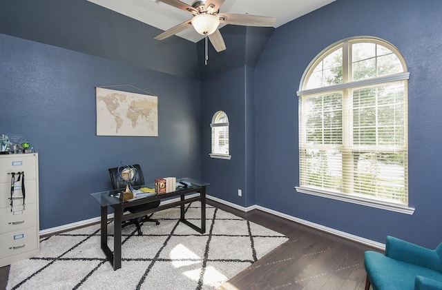 home office featuring lofted ceiling, ceiling fan, baseboards, and wood finished floors