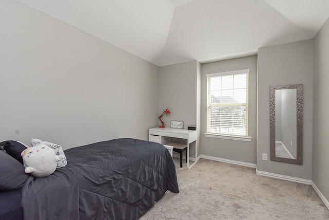 bedroom with vaulted ceiling, baseboards, and light colored carpet