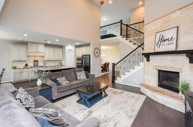 living room with baseboards, dark wood finished floors, stairway, a fireplace, and recessed lighting