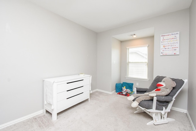 sitting room with carpet floors, visible vents, and baseboards