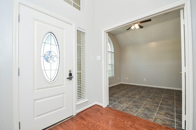 entryway featuring baseboards, vaulted ceiling, and a ceiling fan