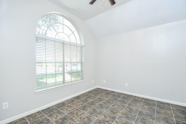 spare room featuring vaulted ceiling, plenty of natural light, and baseboards