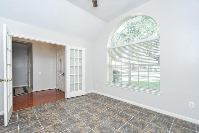 empty room with ceiling fan, baseboards, and vaulted ceiling