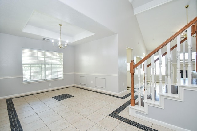 interior space featuring a notable chandelier, visible vents, baseboards, stairway, and a tray ceiling