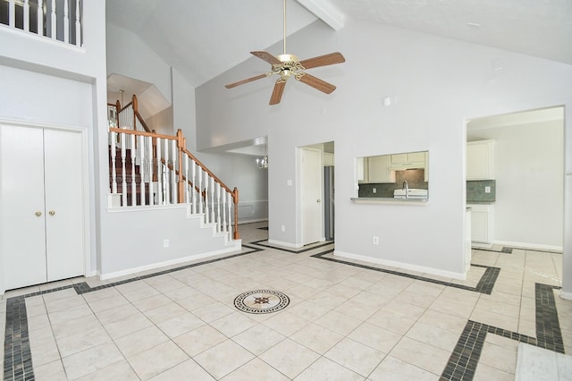 unfurnished living room featuring beam ceiling, light tile patterned floors, ceiling fan, baseboards, and stairs