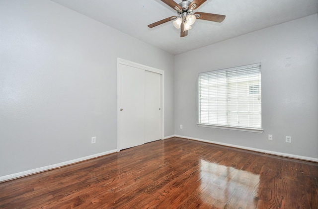 unfurnished room with ceiling fan, wood finished floors, and baseboards