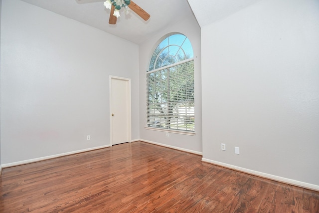 unfurnished room featuring a healthy amount of sunlight, ceiling fan, baseboards, and wood finished floors