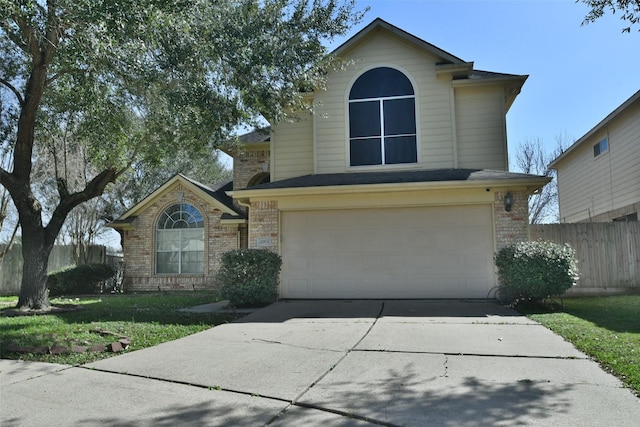 traditional home featuring driveway, an attached garage, fence, a front lawn, and brick siding