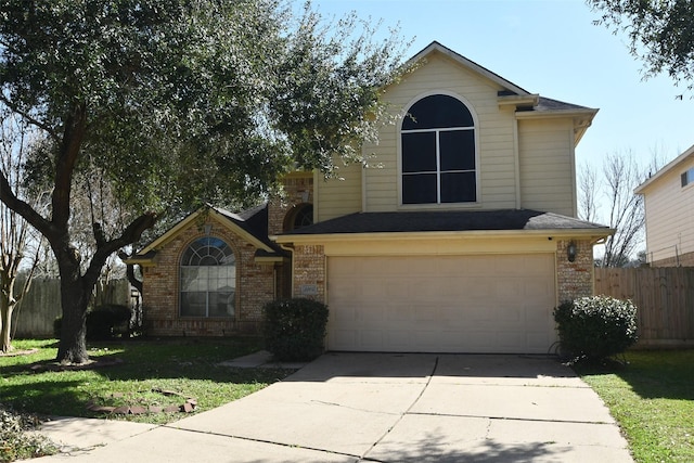 traditional-style home featuring a garage, brick siding, fence, driveway, and a front yard