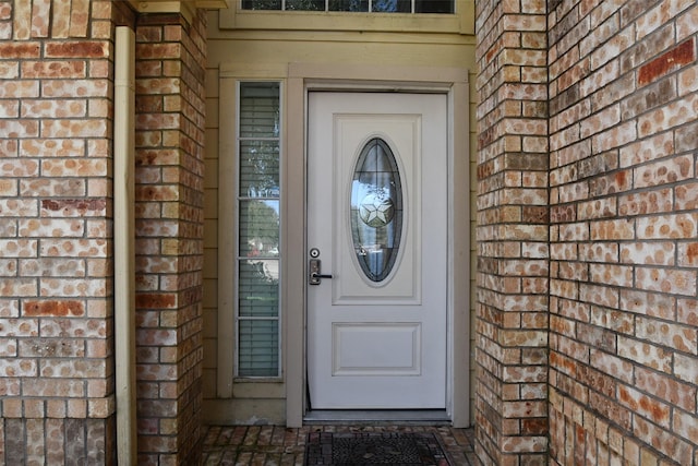 view of exterior entry with brick siding