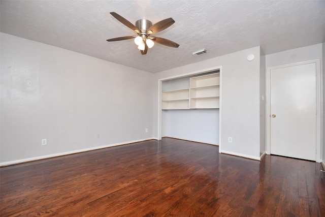 unfurnished bedroom featuring visible vents, ceiling fan, a textured ceiling, wood finished floors, and baseboards