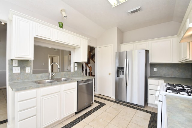 kitchen with visible vents, lofted ceiling, stainless steel appliances, white cabinetry, and a sink