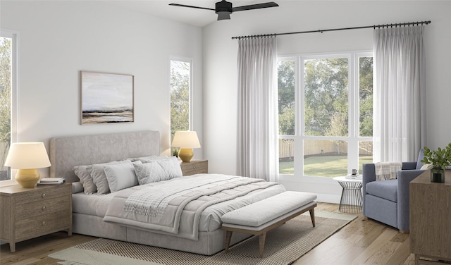 bedroom featuring ceiling fan, wood finished floors, and multiple windows