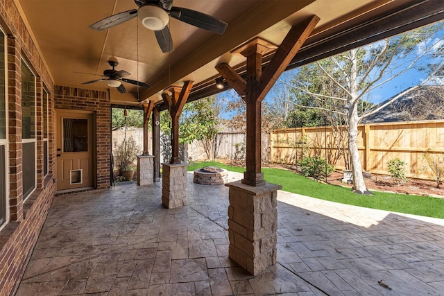 view of patio with an outdoor fire pit, a ceiling fan, and a fenced backyard