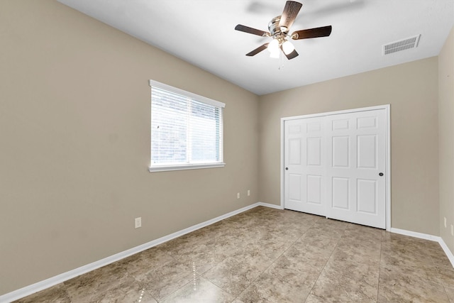 unfurnished bedroom featuring baseboards, visible vents, ceiling fan, and a closet